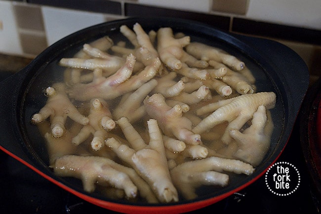 Place chicken's feet into a pot of rapidly boiling salted water, blanch for 5 minutes and drain well. Set aside (or you can place in the fridge for a day until you need to cook further).