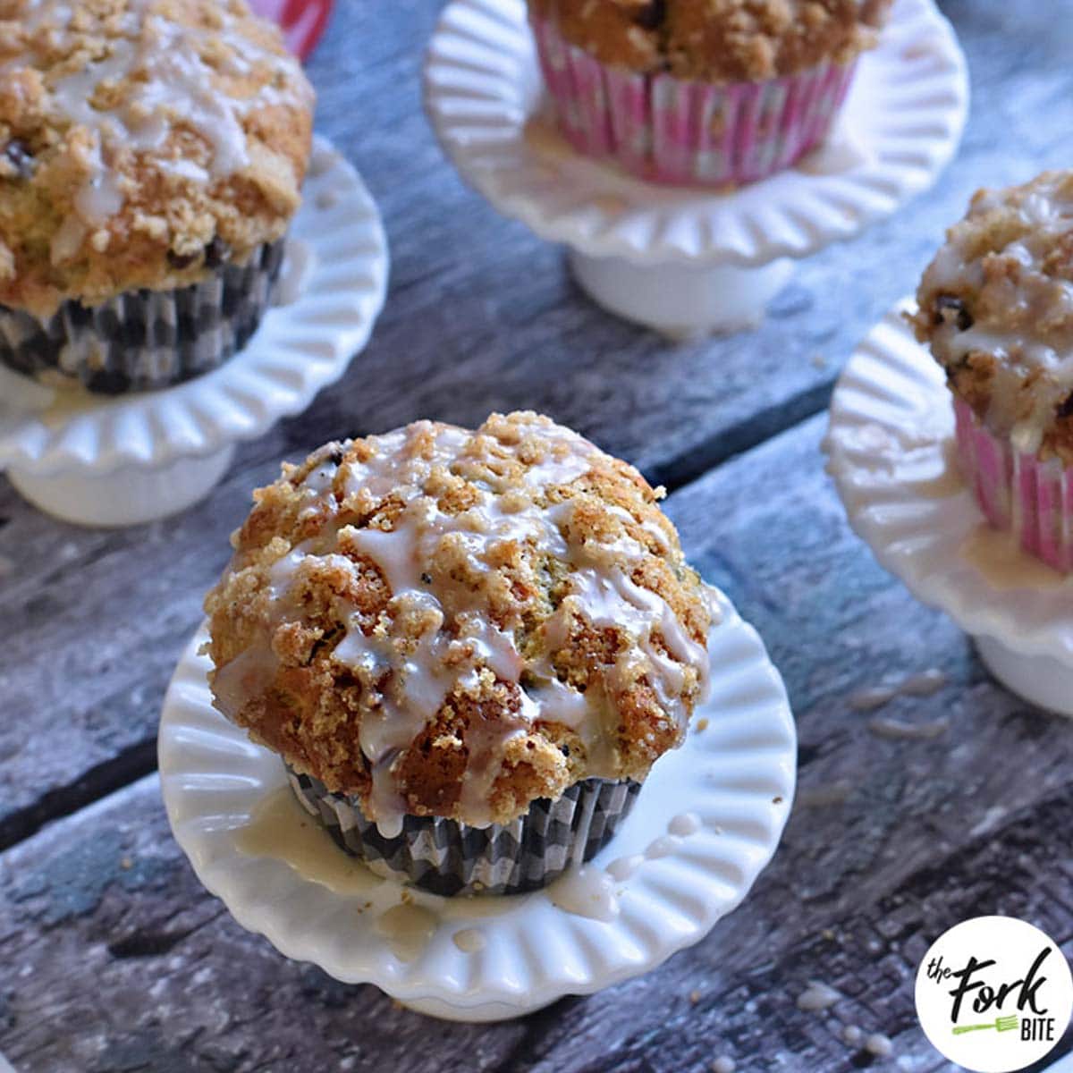 These incredibly moist, soft Banana Chocolate Chip Muffins are topped with (streusel) crumb toppings and then drizzled with a vanilla icing. Perfect for breakfast or a snack!