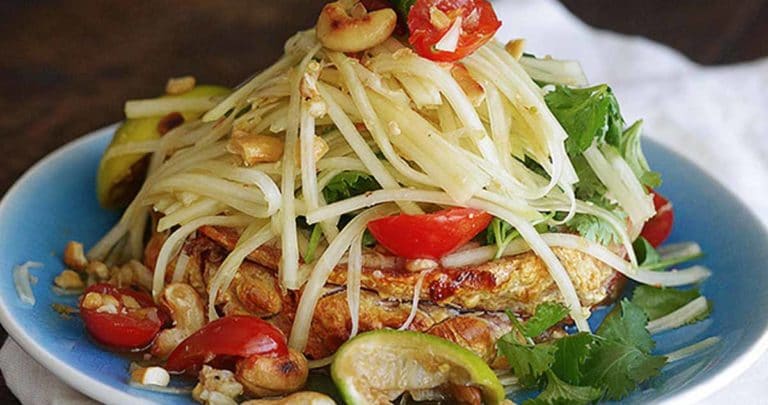 A refreshing and flavorful salad that's full of exotic spicy kick. This Thai Green Papaya Salad can include chopped peanuts, cilantro, tomatoes, and sliced green beans