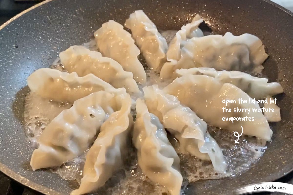 Take the lid off and turn the heat up to medium, let the slurry cook for another one or two minutes, it will start off as a thick paste but as it continues to cook the paste will evaporate and becomes a thin coating until the potstickers’ bottoms get crispy.