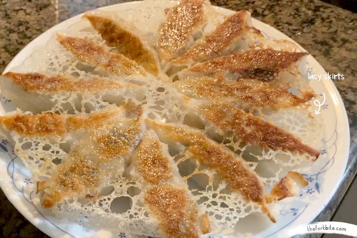 Place a plate on top of the skillet and quickly flip the dumplings so the golden brown lacy skirts face up. Make sure to use a plate that is a bit wider than the skillet.