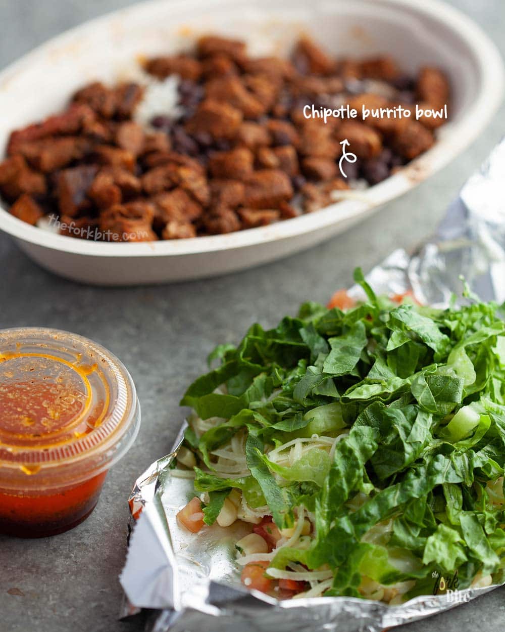 A Chipotle bowl consists of rice, beans, and veggies, plus a few other delicious ingredients. They all come together, served in a disposable bowl.