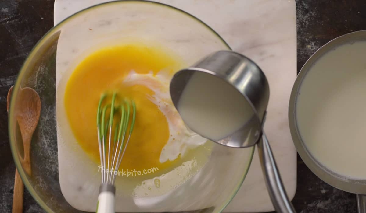 Add the hot milk into the egg mixture slowly. Distribute the milk by ladling with one hand as you stir in medium speed with your other hand using a whisk.
