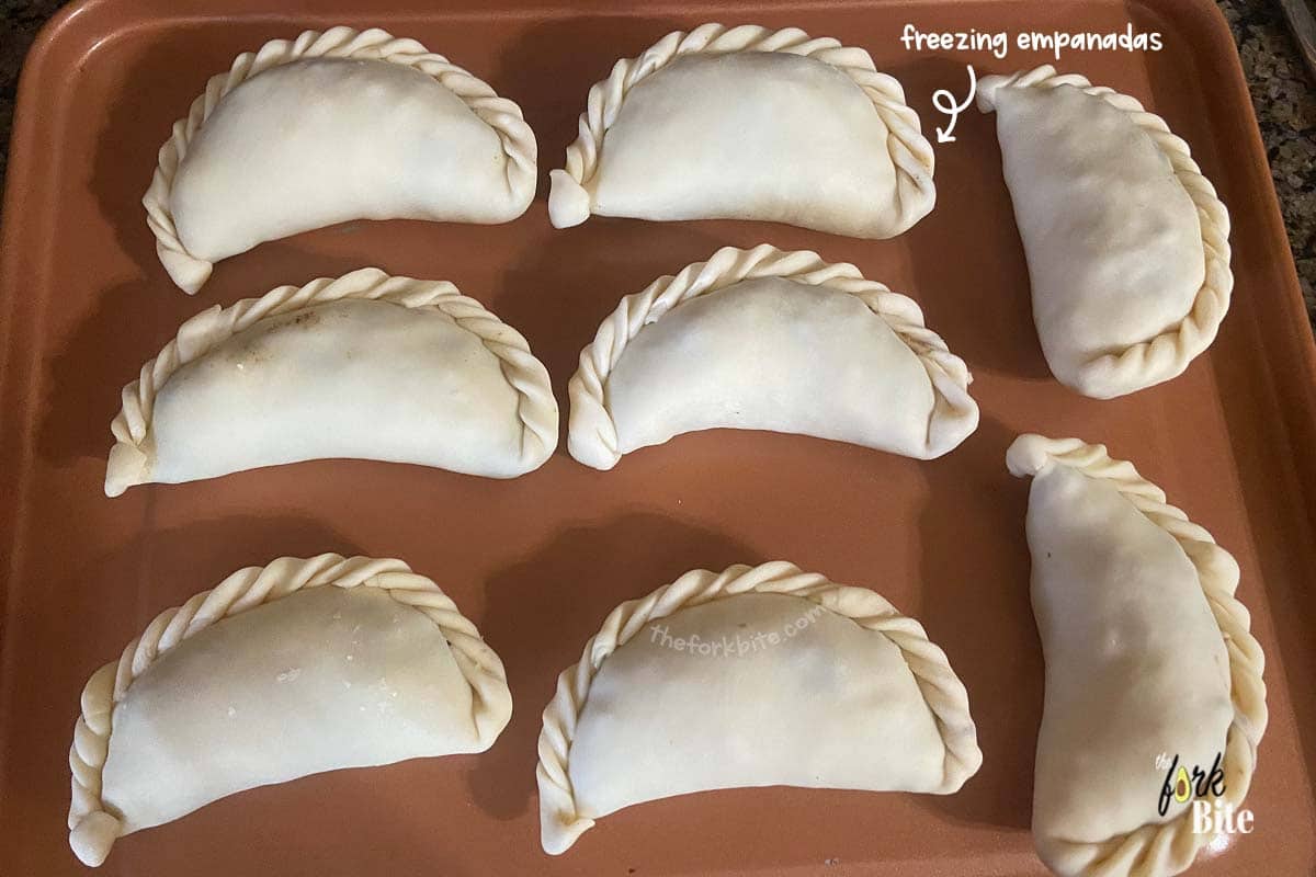 Lay your unbaked empanadas beside each other on a parchment-lined baking sheet and ensure that they don't touch. If they do, they will stick together during freezing.