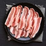 It's super easy to cook bacon in batches; whether you're cooking for a potluck or stocking your freezer for quick breakfast or brunch, this step by step instructions is for you.