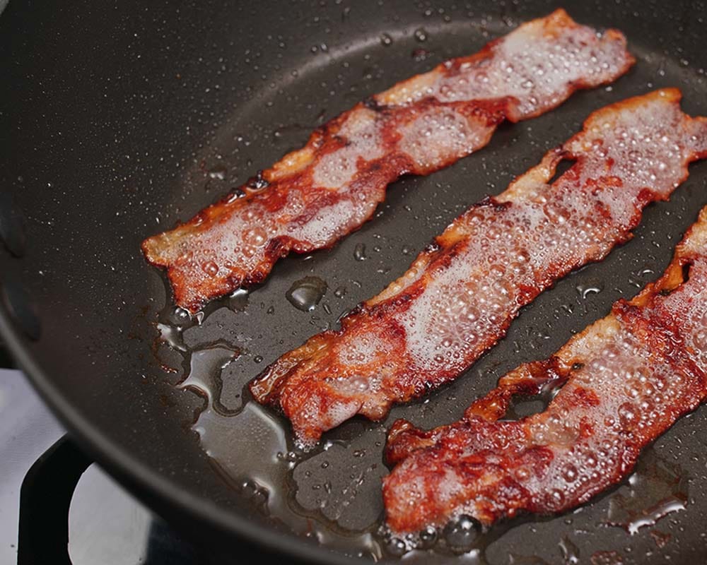 Add a few teaspoons of bacon grease or (your preferred cooking oil) into the pan. Add in the bacon and heat it at low temperatures.