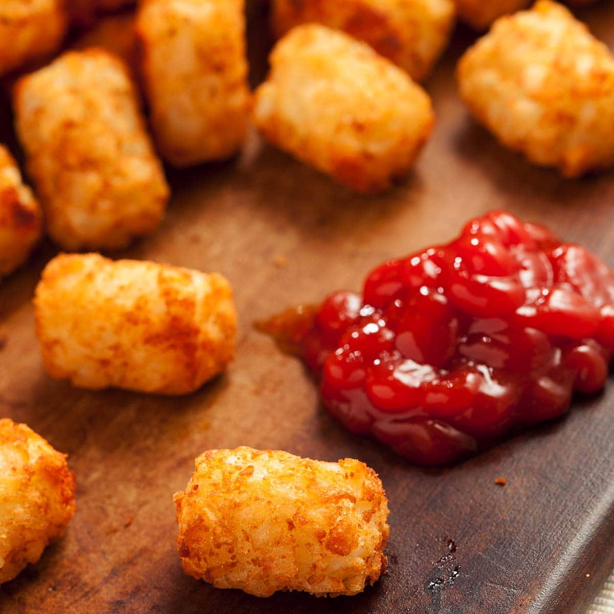 Tater tots meld together because of the combination of proteins and wet starches. When these two sticky ingredients increasingly touch each other, the sticker and chewier the tater tots become.
