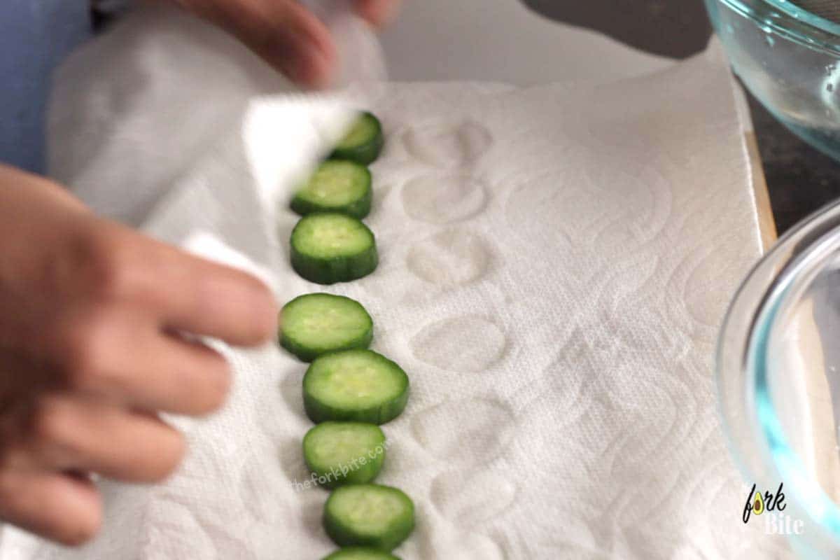 Take the pre-brined slices of cucumber, pat dry with kitchen paper, and tip them into a one-gallon-sized ziplock bag. Pour in the marinade.