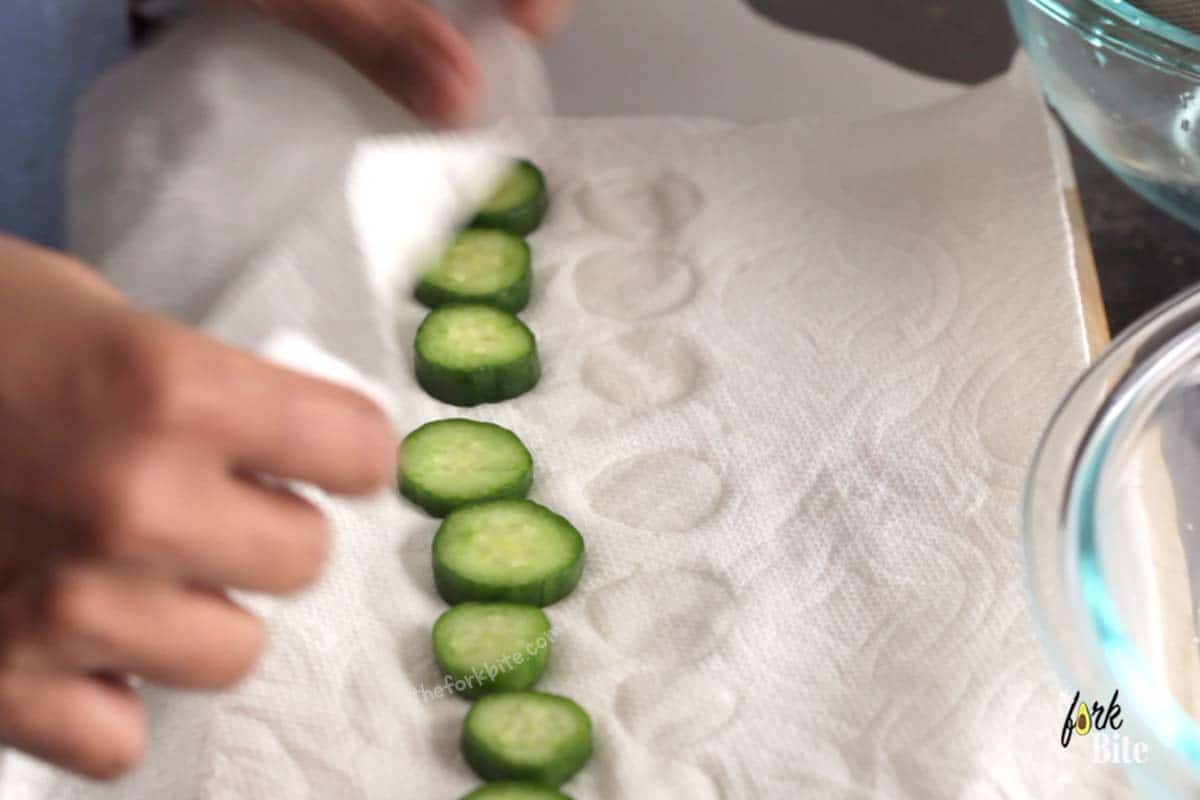 Take the pre-brined slices of cucumber, pat dry with kitchen paper, and tip them into a one-gallon-sized ziplock bag. Pour in the marinade.
