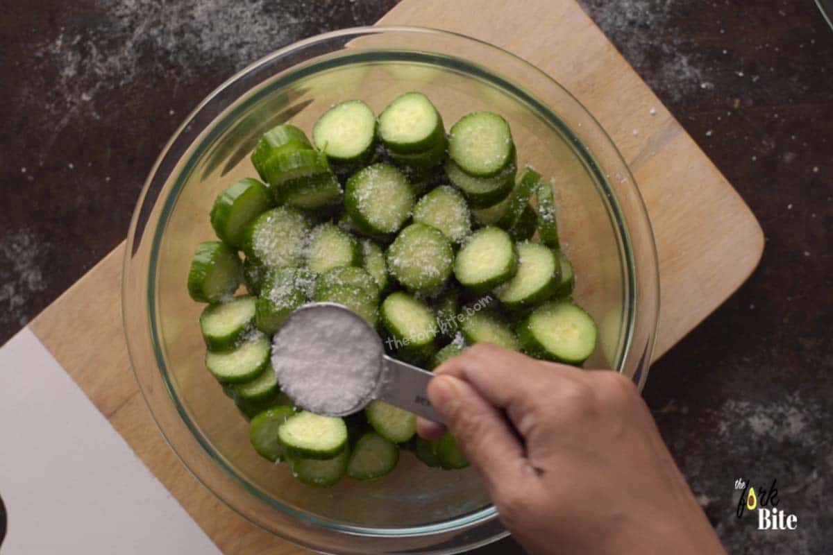 When you salt sliced cucumber, it draws out the water using a process called osmosis. What happens is that when salted and left for a few minutes, the salt absorbs the water and what remains is a cucumber that is a little drier.