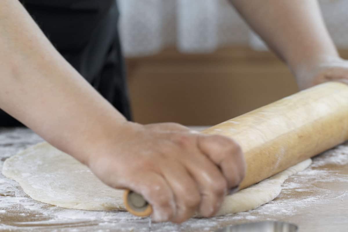 Take the dough out of your mixing bowl or bread machine and put it onto a pre-floured working surface. Kneed it firmly and briefly and shaped into a ball.
