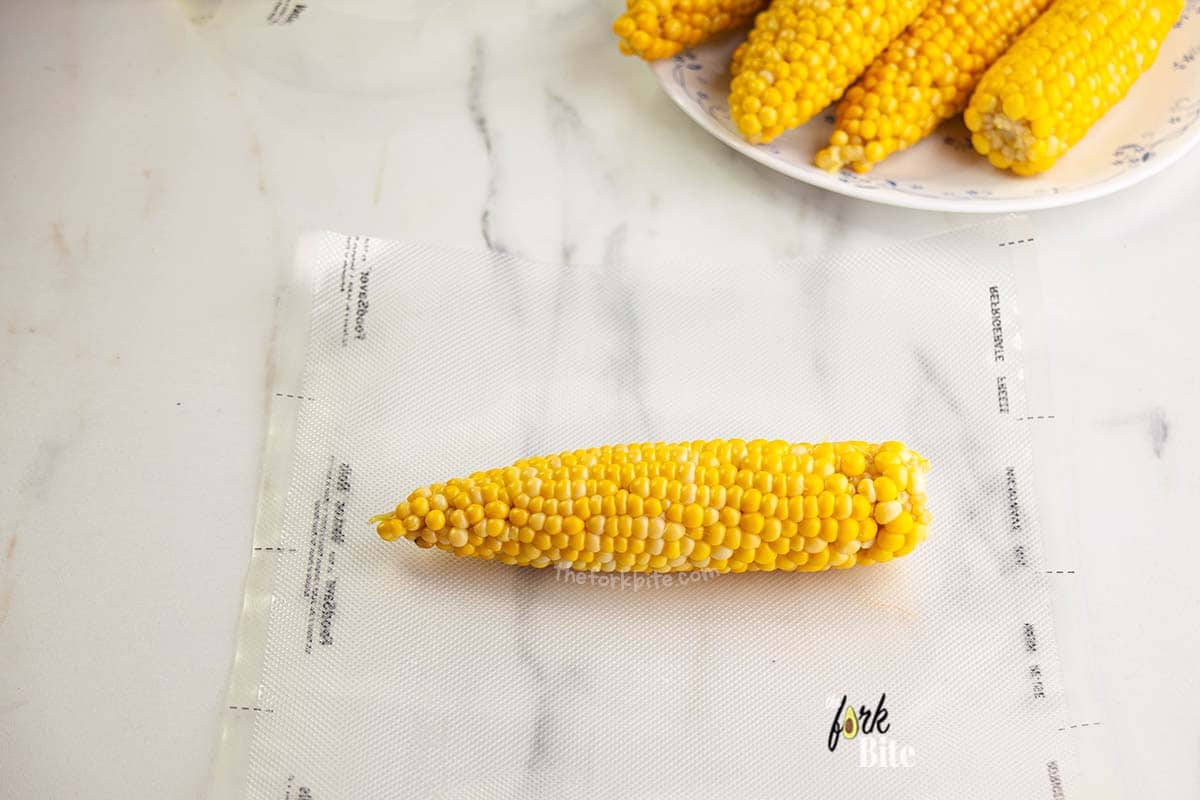 After blanching and ice water bath the corn on the cob, place it into the Food Saver bag. Align the opening of the bag onto the clamp of the FoodSaver device.
