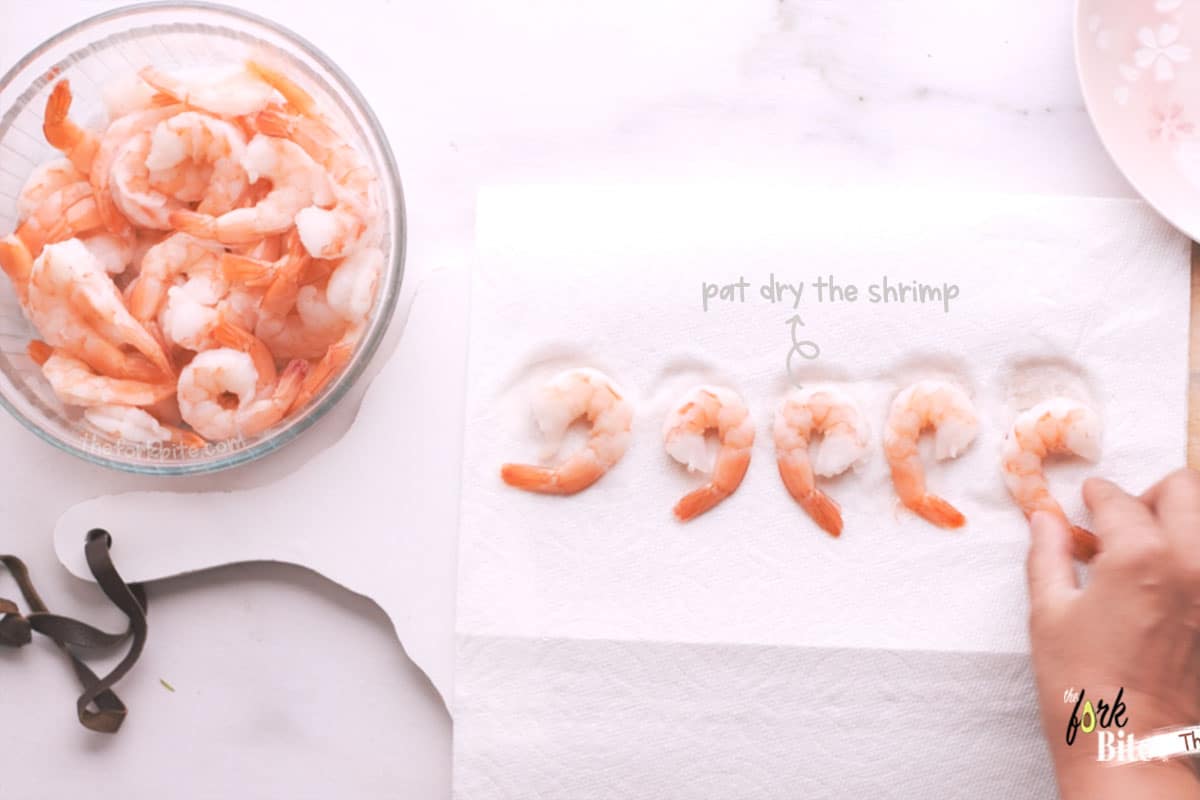 Using a paper kitchen towel, dab the shrimp dry, add ¼ teaspoon of salt, and a few fresh ground black pepper twists.