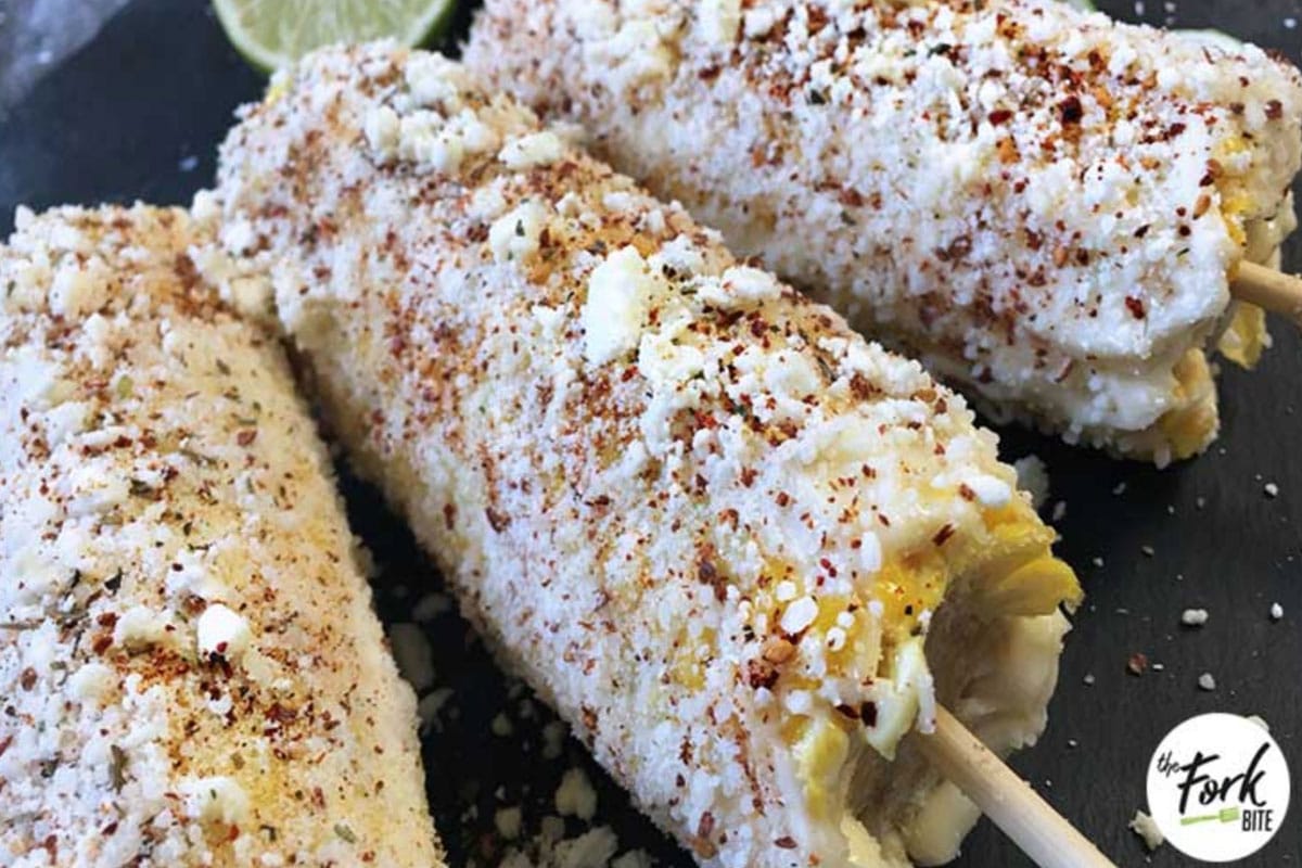 Roasted over an open grill or barbecue, this corn on the cob dish is smothered in butter, chili powder, Cotija cheese, lime, and mayo or Crema Fresca.