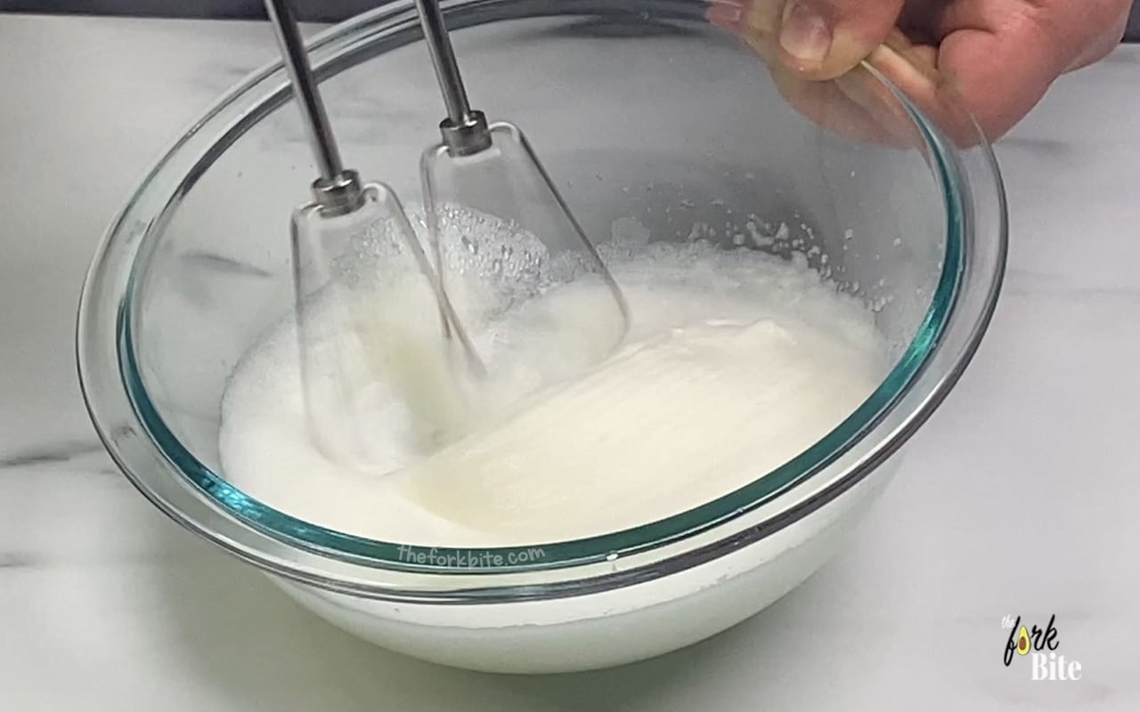 Pull out that whisk and start on the egg whites. Whisk using a handheld mixer until it bubbles then add 1 tsp of sugar.