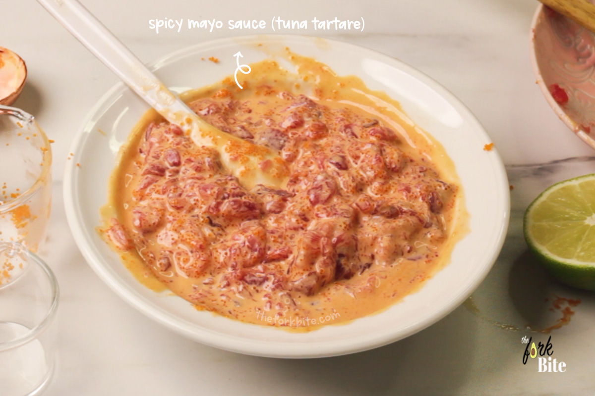 Take a small mixing bowl, and into it, spoon two tablespoons of the Kewpie mayonnaise, one tablespoon of the Sriracha chili sauce, and one teaspoon of raw honey (optional).