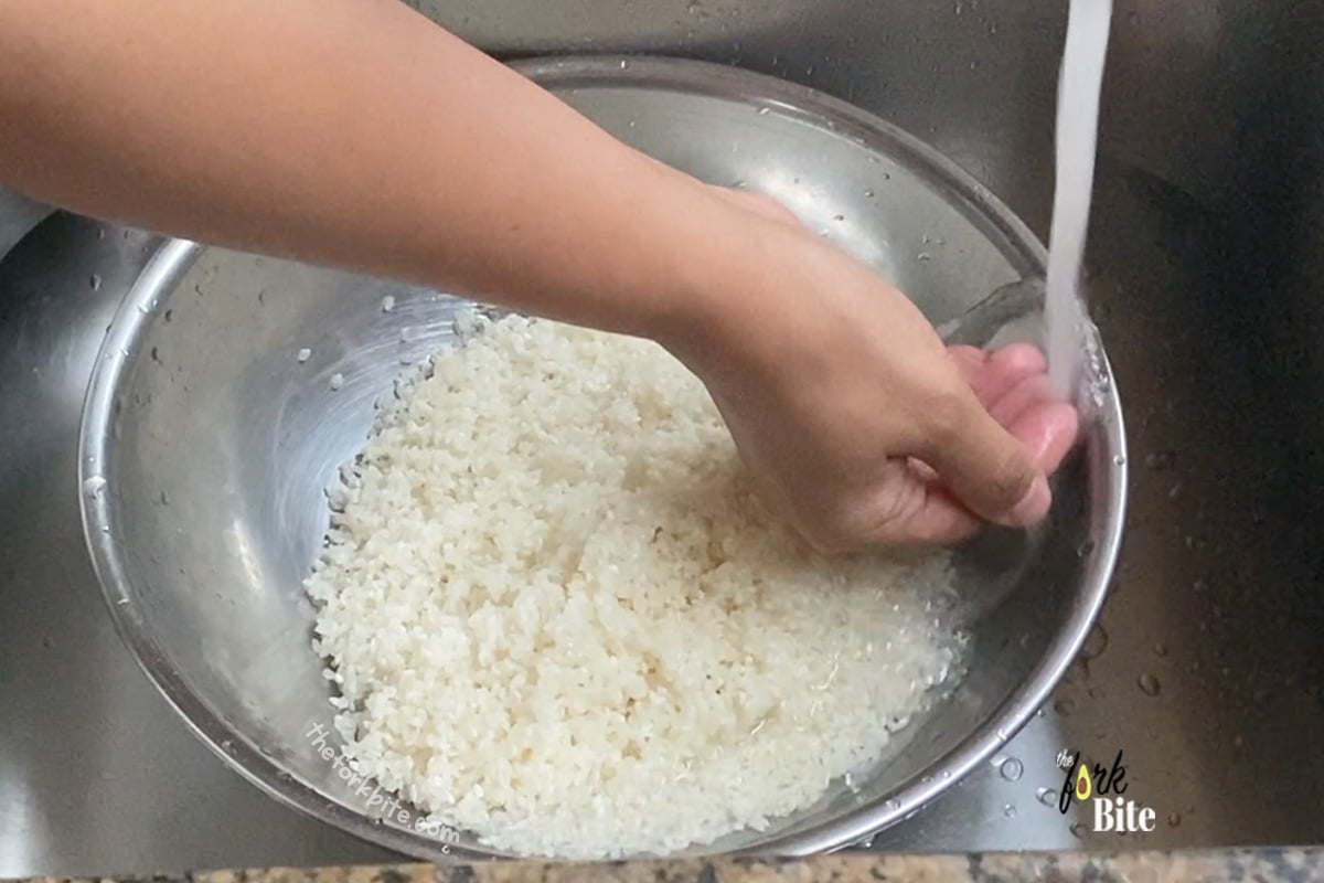 Transfer the rice into a large bowl, and fill the bowl with cold water. Remember, don't pour the water onto the rice too forcefully. Gently rub the rice between your fingers or use your fingers to stir it.