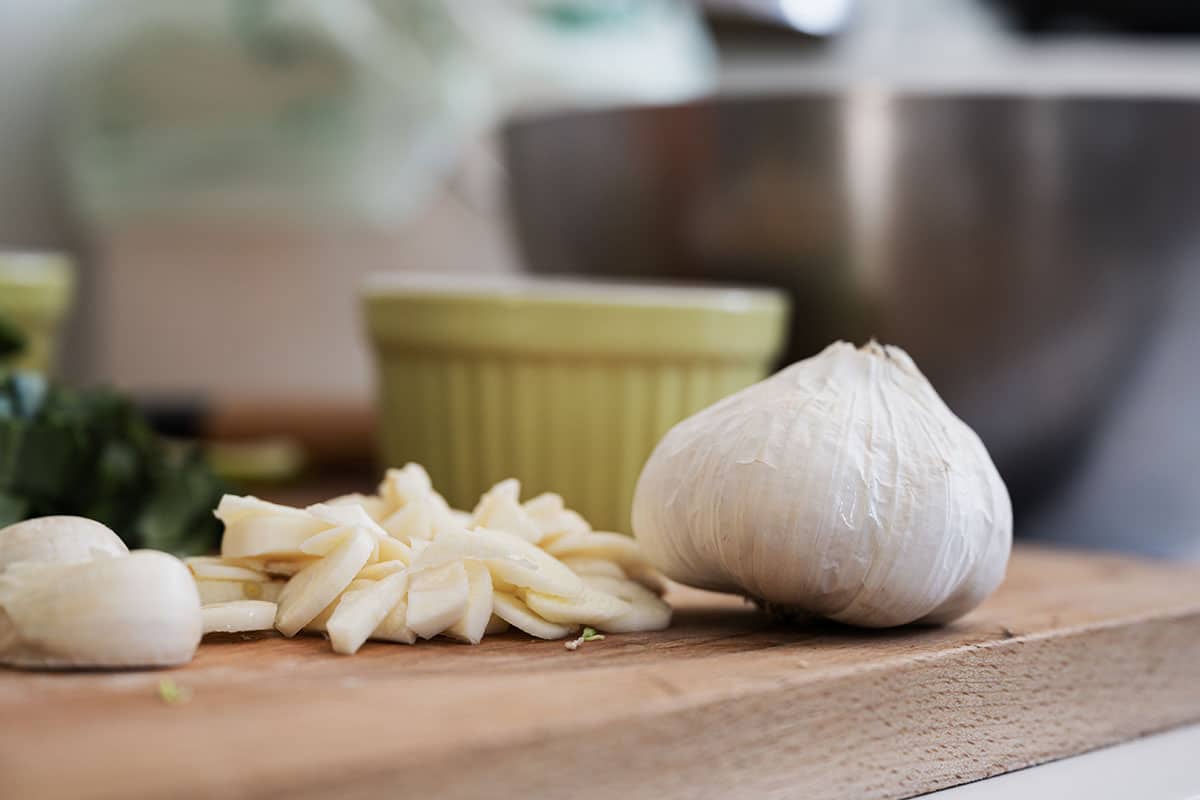 Make many vertical cuts from top to bottom, not quite cutting through, followed by some horizontal cuts. Cut diagonally across the garlic to finish off, and this will give you nice, similar-sized pieces.