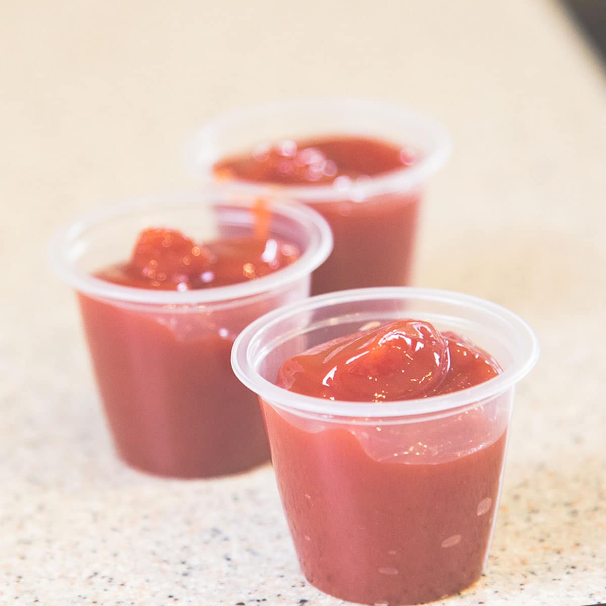 It's not a good idea to freeze plastic bottles of ketchup, especially when they're full. Don't forget that it has high water content. Freezing it will cause it to expand and could easily split the bottle.
