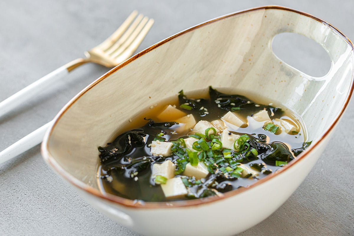 Miso soup is one of the traditional accompaniments to any Japanese meal. It only takes ten minutes to make and uses just five ingredients - dashi, miso paste, Negi (spring onions), tofu, and wakame (seaweed).