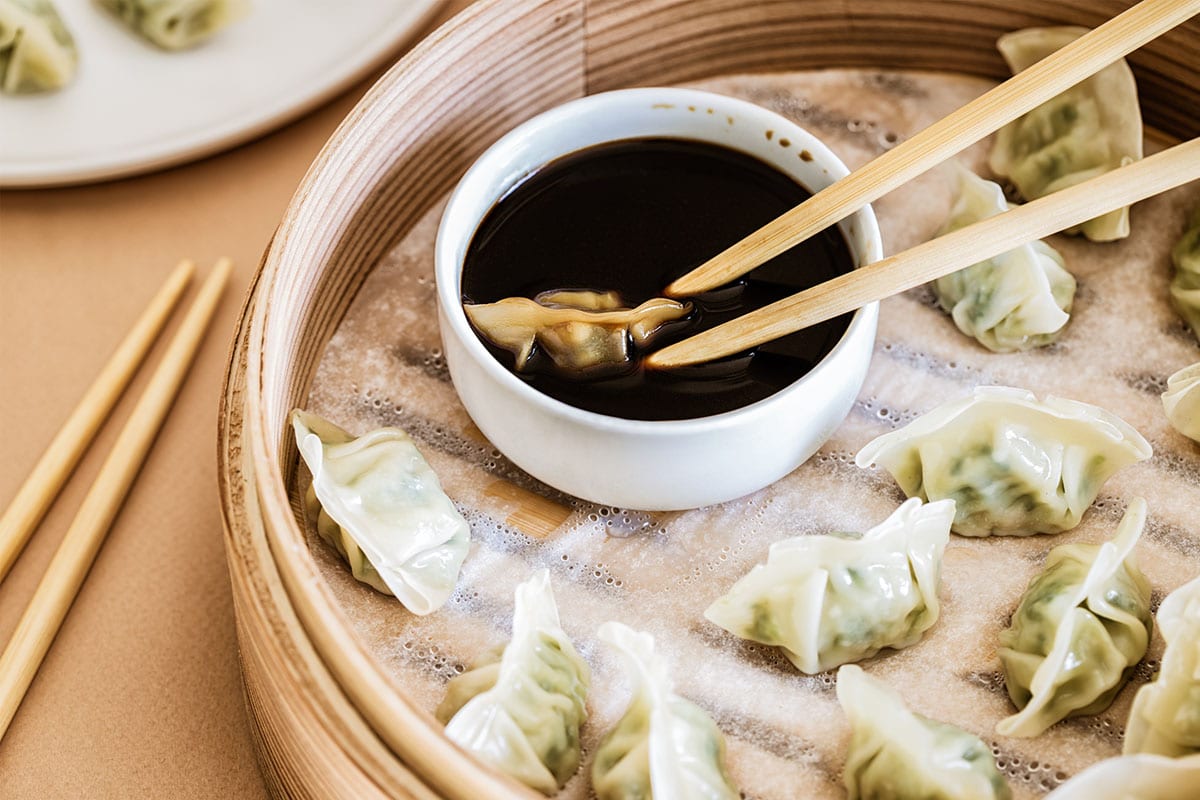 The best method of preventing food from sticking to the bottom of your bamboo steamer basket is to line it with a sheet of bamboo steamer liner or parchment waxed paper.