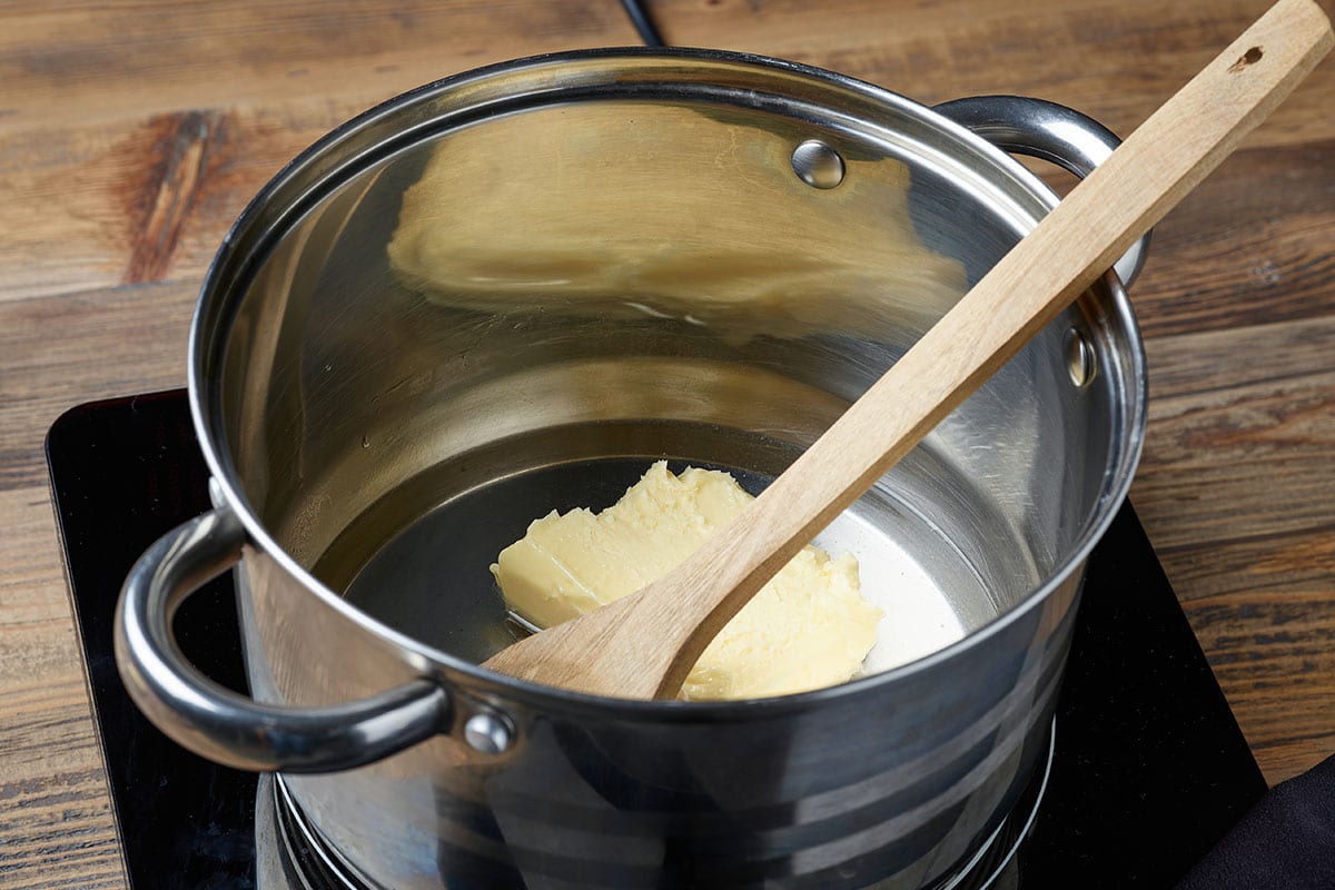 Transfer the unsalted butter into a small heavy-bottomed pan. Place on the stovetop over low heat. Allow the butter to melt.