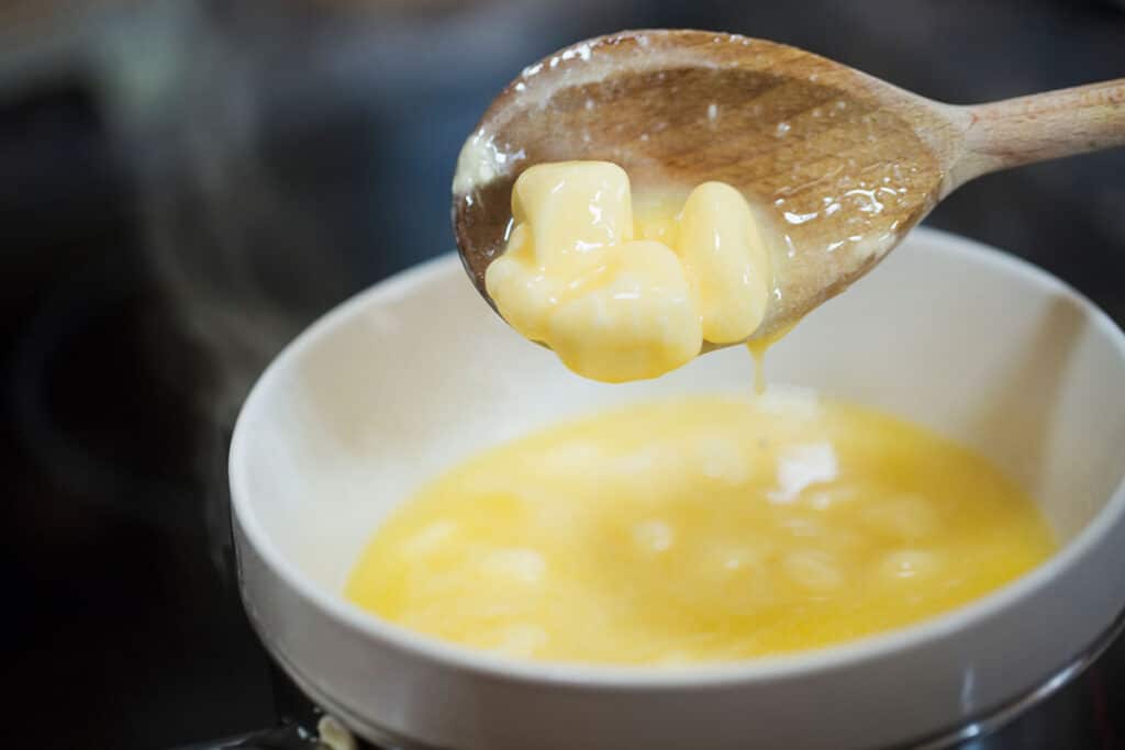 Transfer butter into a microwave-safe cup or dish. Select the microwave's high setting and blast for one minute or until the butter has melted. Skim off the foam.