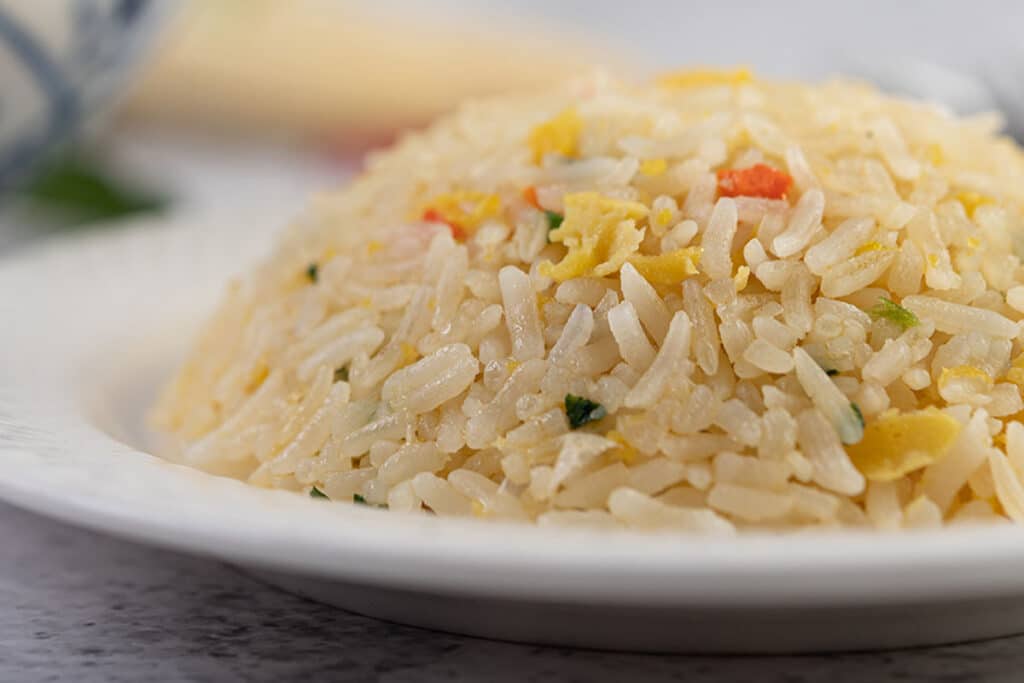 Always use leftover, cold, cooked rice. When left overnight in the fridge, rice grains always firm up. It makes them much easier to separate and significantly reduces the chances of mushy fried rice.
