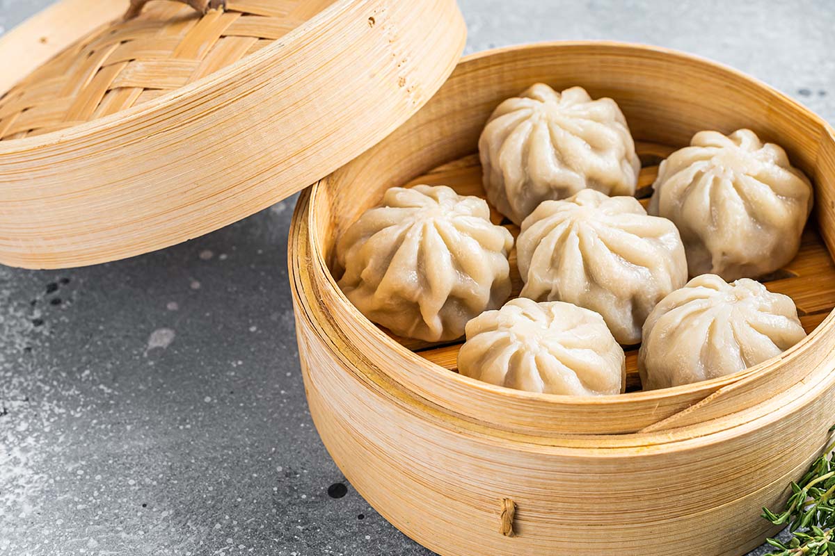 Xiao Long Bao is shaped like a round purse, crimped at the top. It is a soup dumpling - not a dumpling filled with soup - but cooked in soup. The filling is either chopped crab or pork plus some pork collagen.