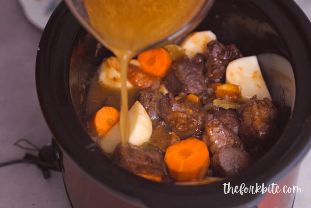 Drop the carrots, potatoes, and bay leaves then pour in the beef broth (or you can also use water). Add in the tomato sauce and soy sauce (or fish sauce).