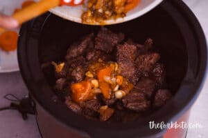 Pour the sauteed vegetables into your slow cooker. Add the rested pieces of beef.