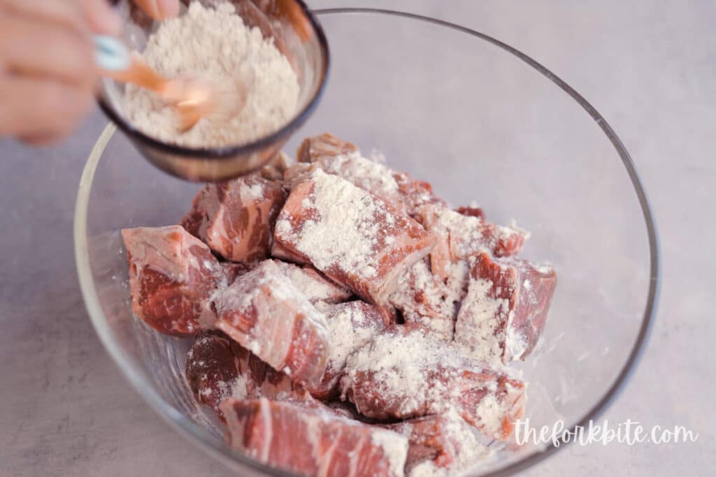 In a large mixing bowl, mix the salt, garlic powder, pepper, and flour. Toss the sliced beef and lightly coat them with the breading mixture.