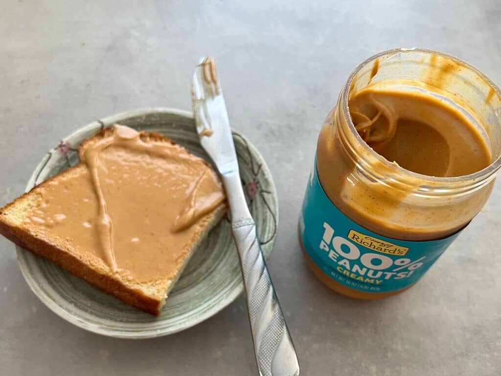 The liquids separating the solid peanut butter body rise to the top, storing the peanut butter upside-down forces the oil at the top to travel through the butter to end up mixing right in them. 