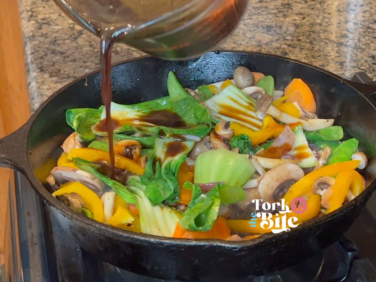 Pour 2 to 3 tablespoon of the prepared stir-fry sauce into the skillet with the vegetables, stirring to coat them evenly. Let the sauce simmer for 1-2 minutes to thicken slightly and allow the flavors to meld.