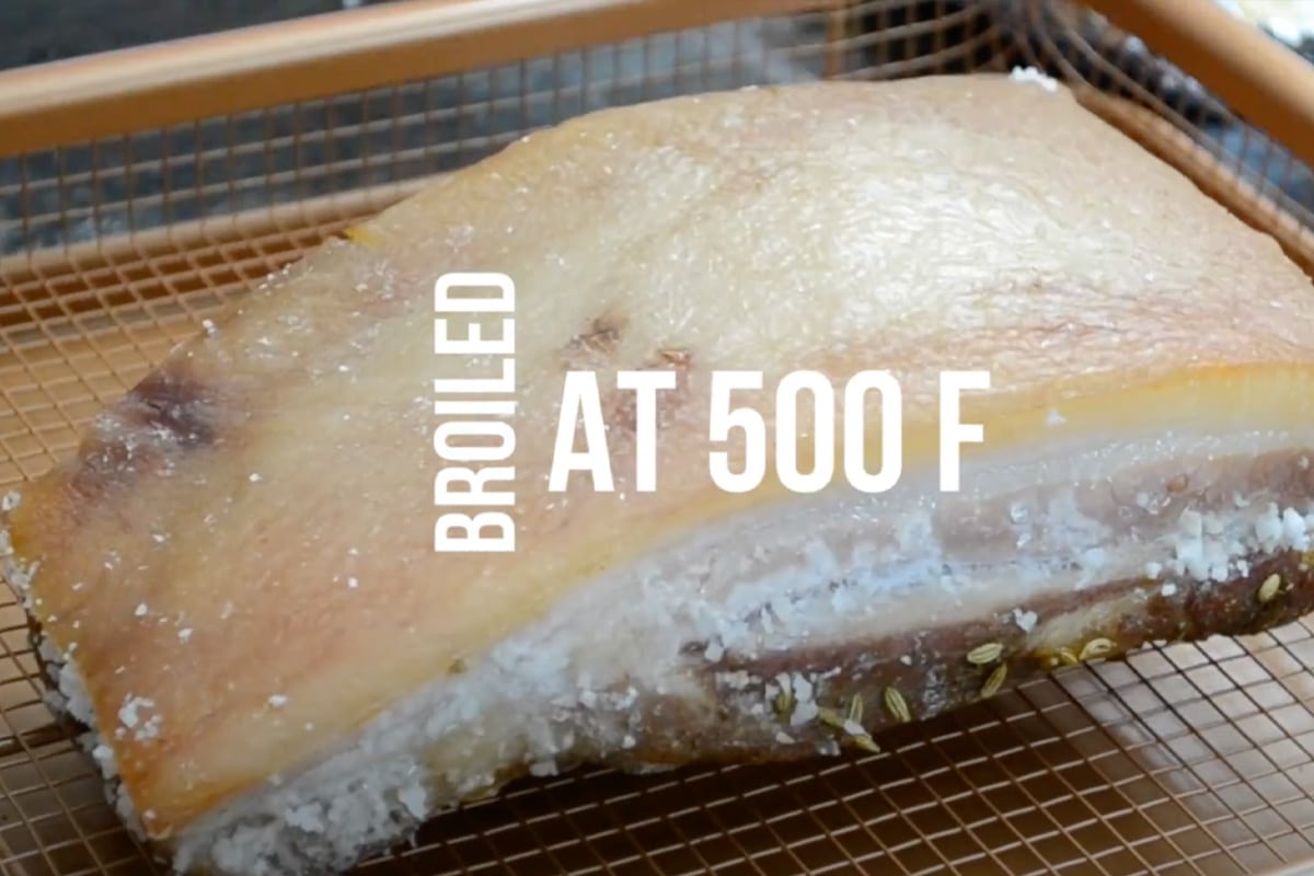 Slide the pork belly under the grill or broiler and let it cook for 20-25 minutes, rotating the tray once. Keep a close eye on it until the skin is golden, crispy, and puffed to perfection.