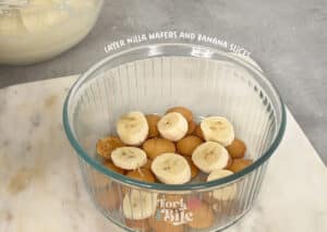 Add a layer of Nilla Wafers to the bottom of your dish(es). Then, add a layer of sliced bananas on top of the wafers.