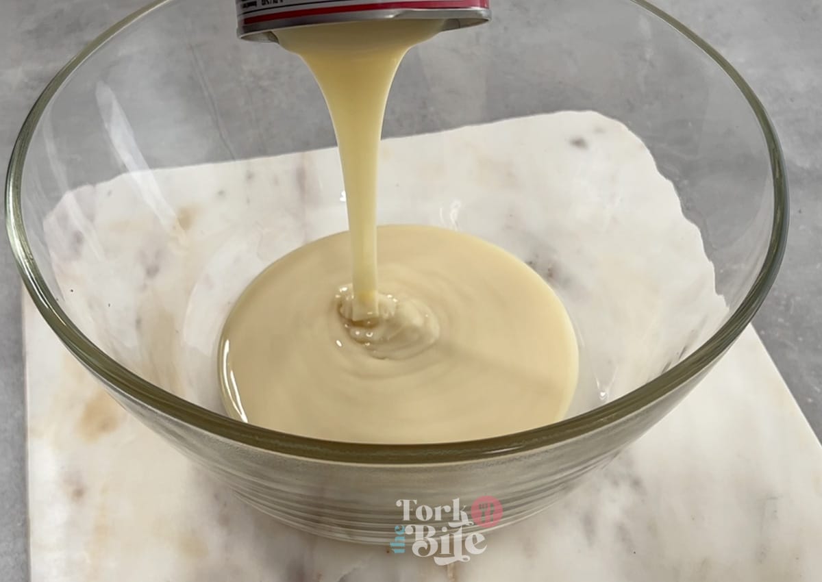 Start by whisking together sweetened condensed milk and water with an electric mixer.