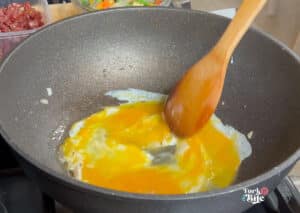 Add the beaten eggs to the pan and scramble them to your desired texture to get started. Once the eggs are cooked to your liking, remove them from the pan and set them aside. 