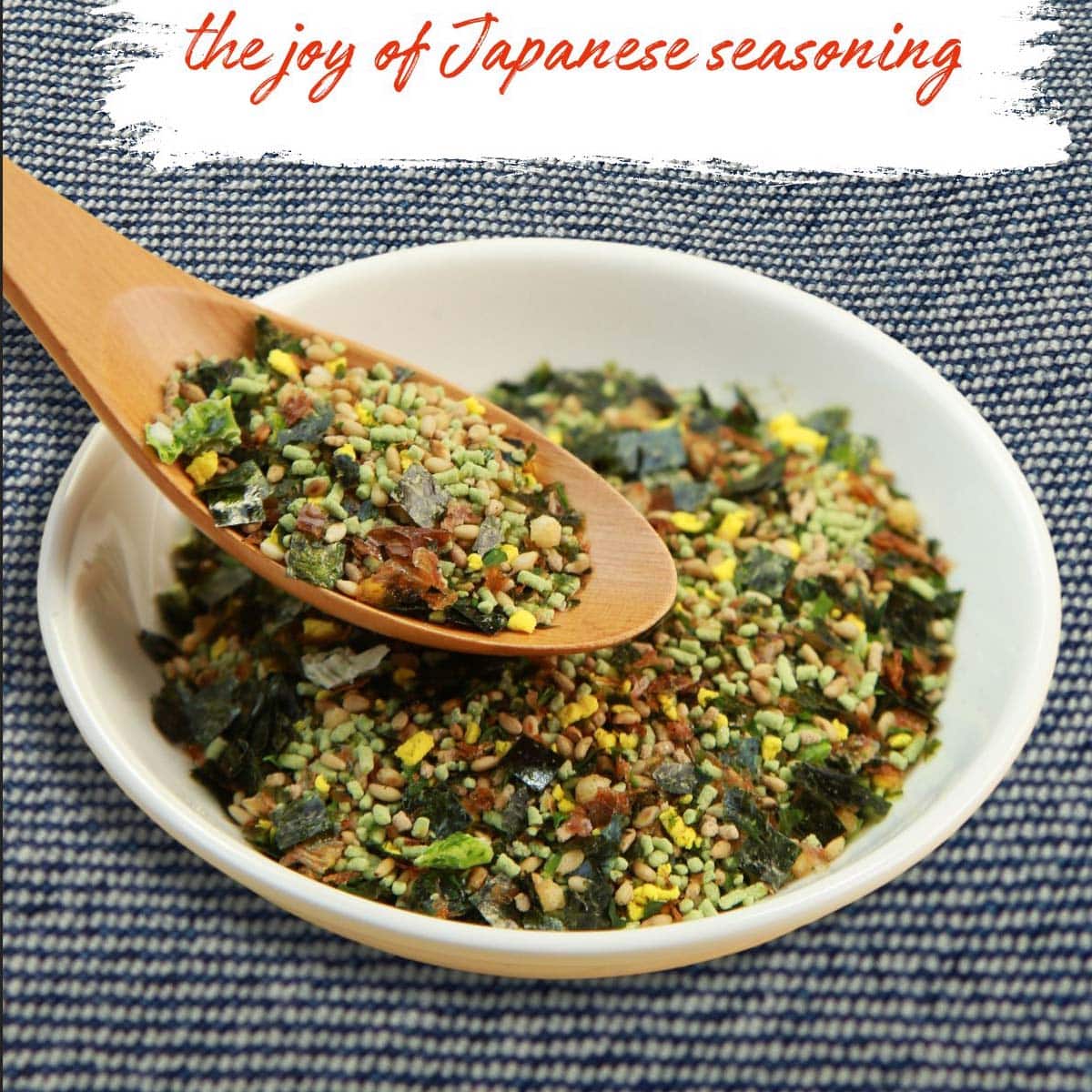 Hand sprinkling homemade Furikake Substitute over a bowl of rice.