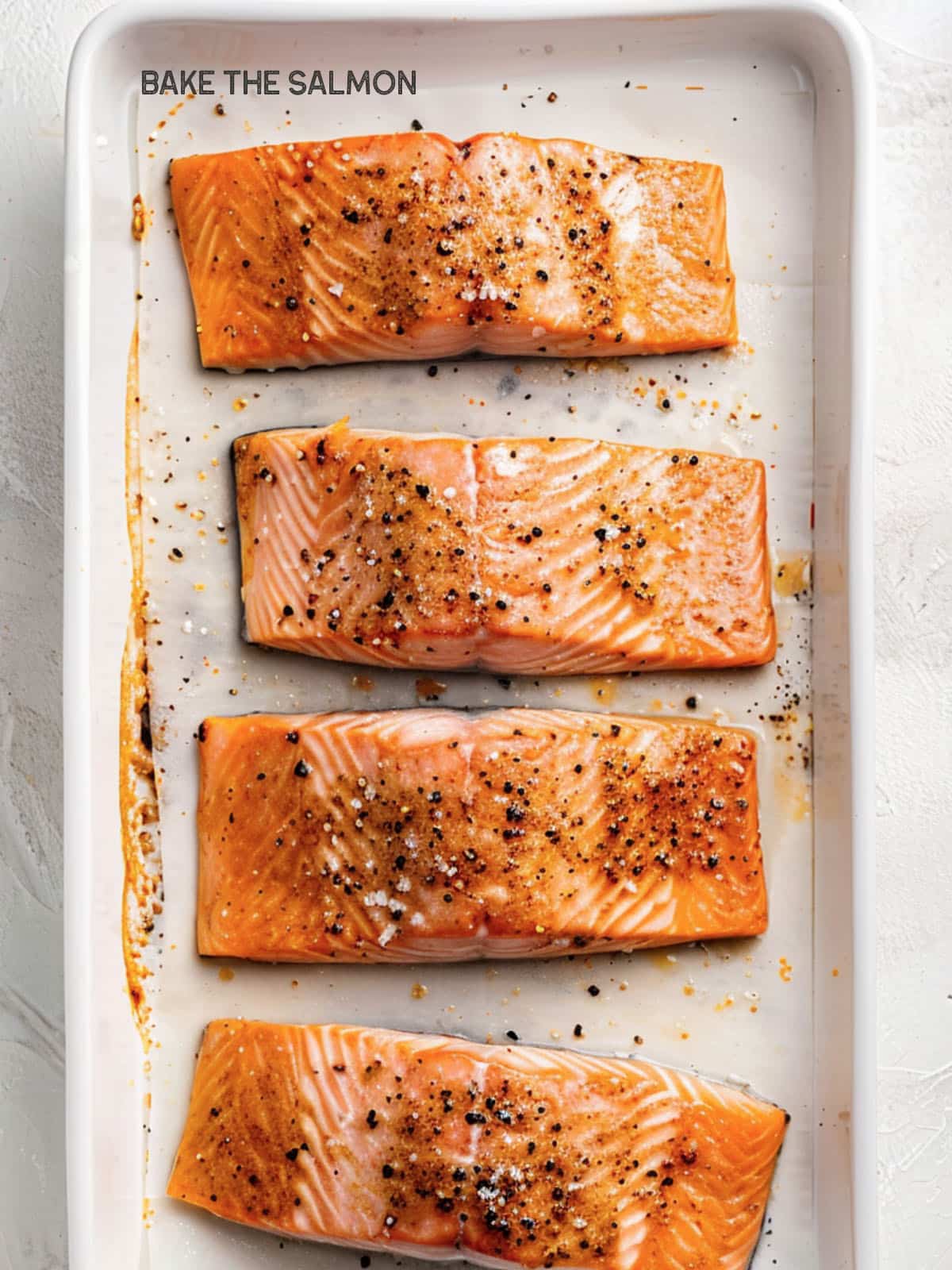 A salmon fillet placed on a baking sheet ready for the oven. 