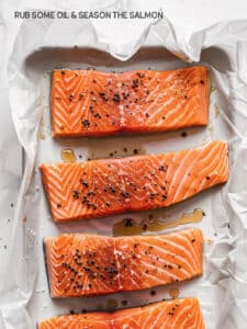 Preparing salmon for baking - oil is drizzled on the fillet and spread, followed by generous seasoning with salt and pepper.