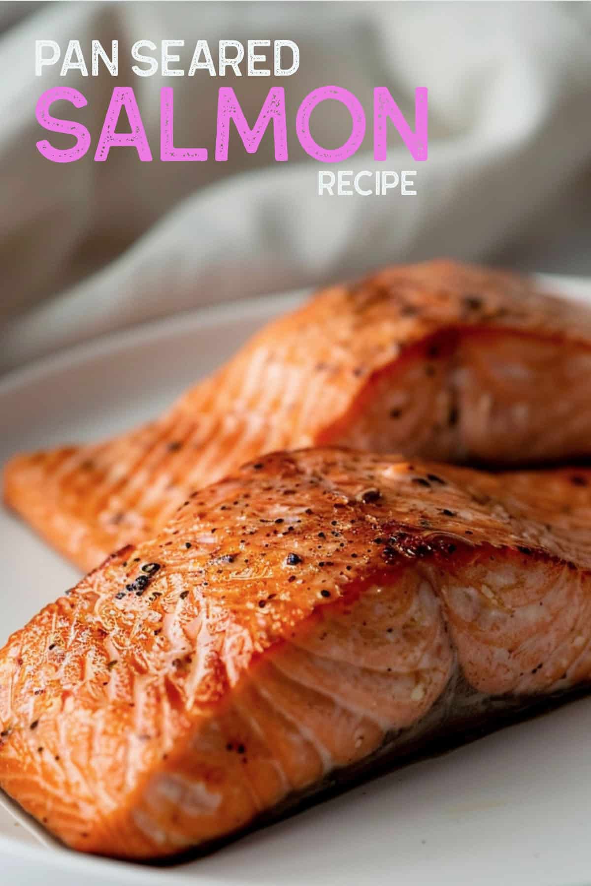 Image of a pan-seared salmon fillet with crispy golden-brown skin, resting on a plate.