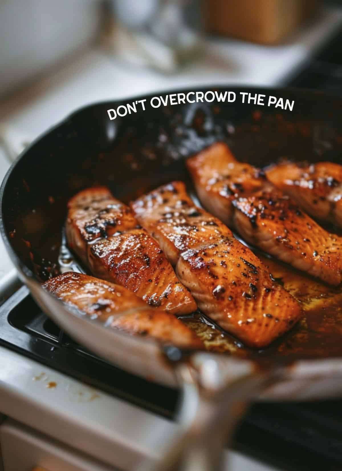 Image of an overcrowded pan with salmon fillets.
