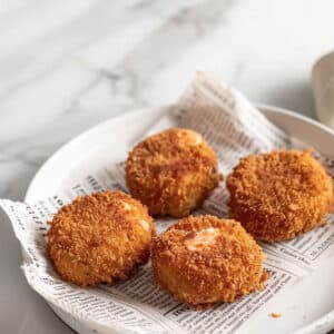 Image of salmon croquettes draining on paper towels, a technique for maintaining their crispy texture.