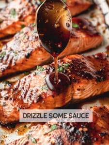 Baked honey glazed salmon with a spoon drizzling extra pan sauce over the fillet.