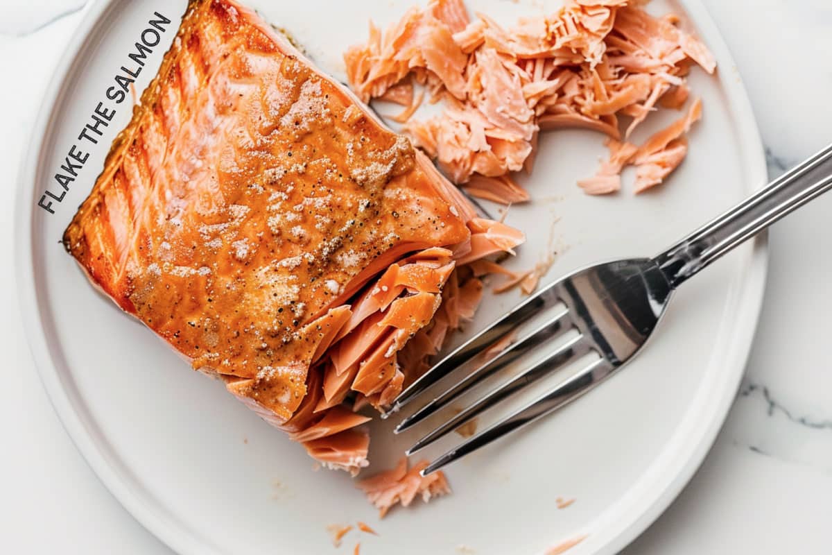Close-up of cooked salmon being flaked for perfect salmon flakes.