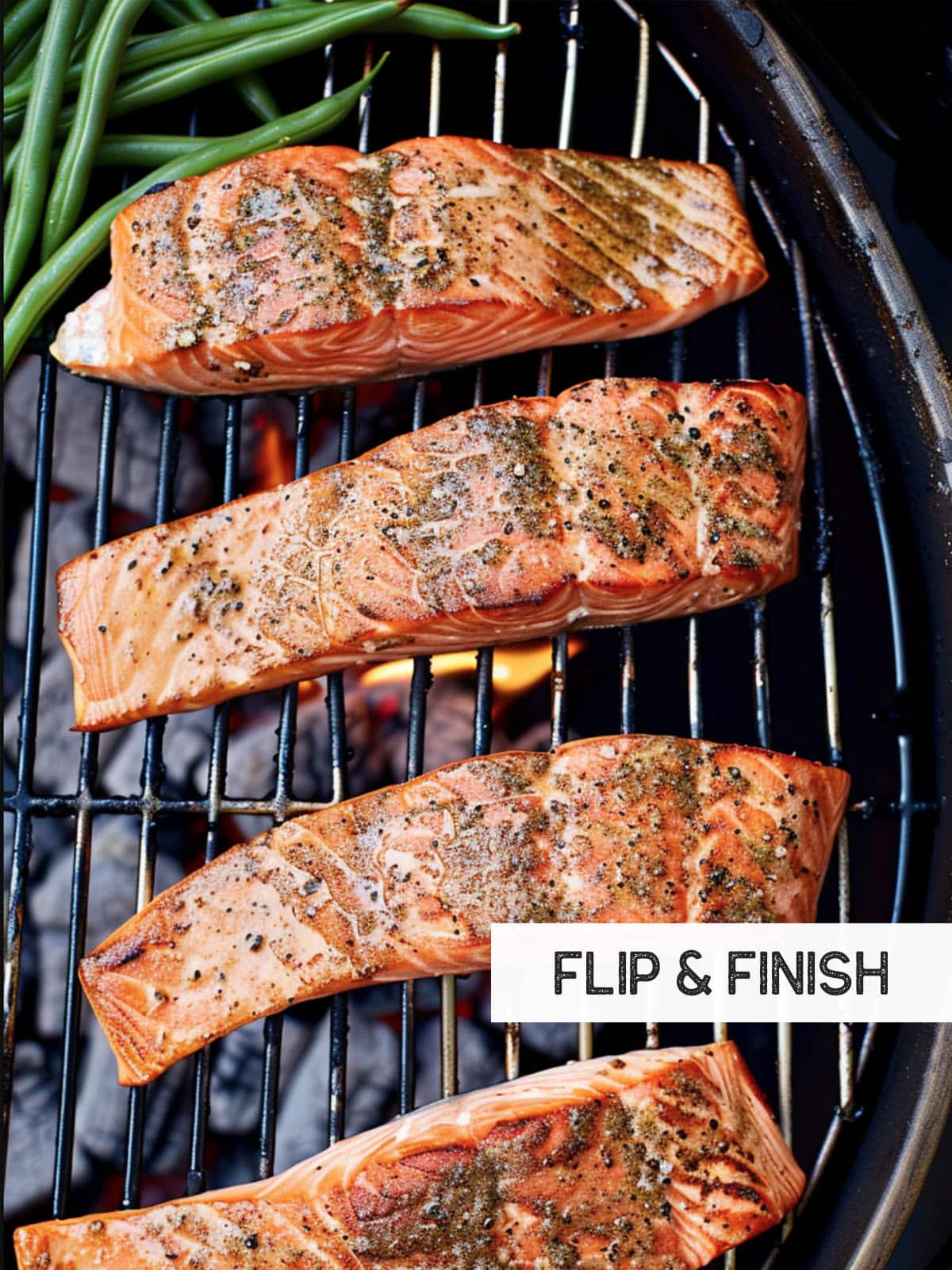 Salmon fillets, perfectly browned on one side, flipped on a hot grill with tongs.