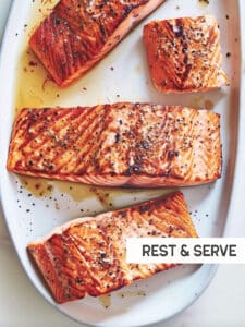 Perfectly cooked grilled salmon rests on a serving platter, lemon wedges ready for a squeeze.