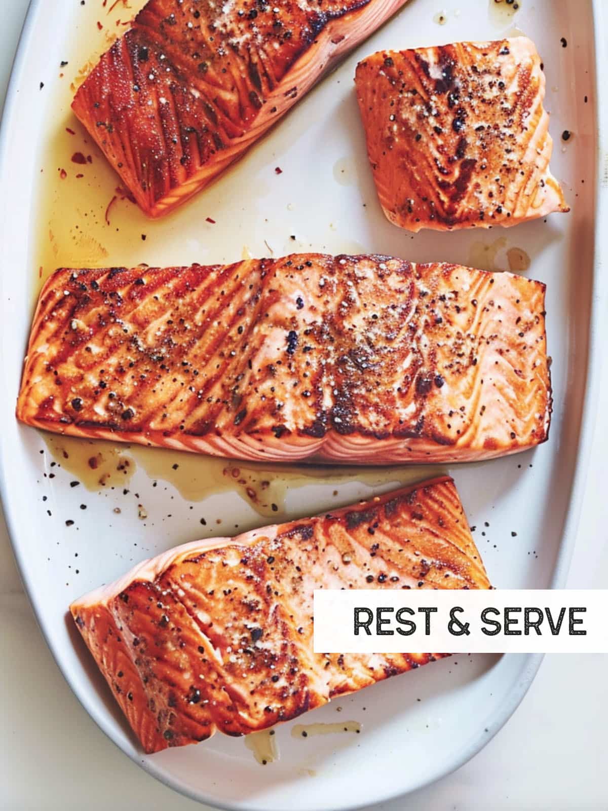 Grilled salmon plated with lemon wedges on the side.