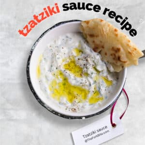 Thick and creamy tzatziki sauce with visible cucumber pieces and fresh dill.